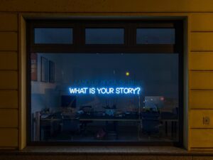 Office window that says what is your story in neon lights | Storybrand